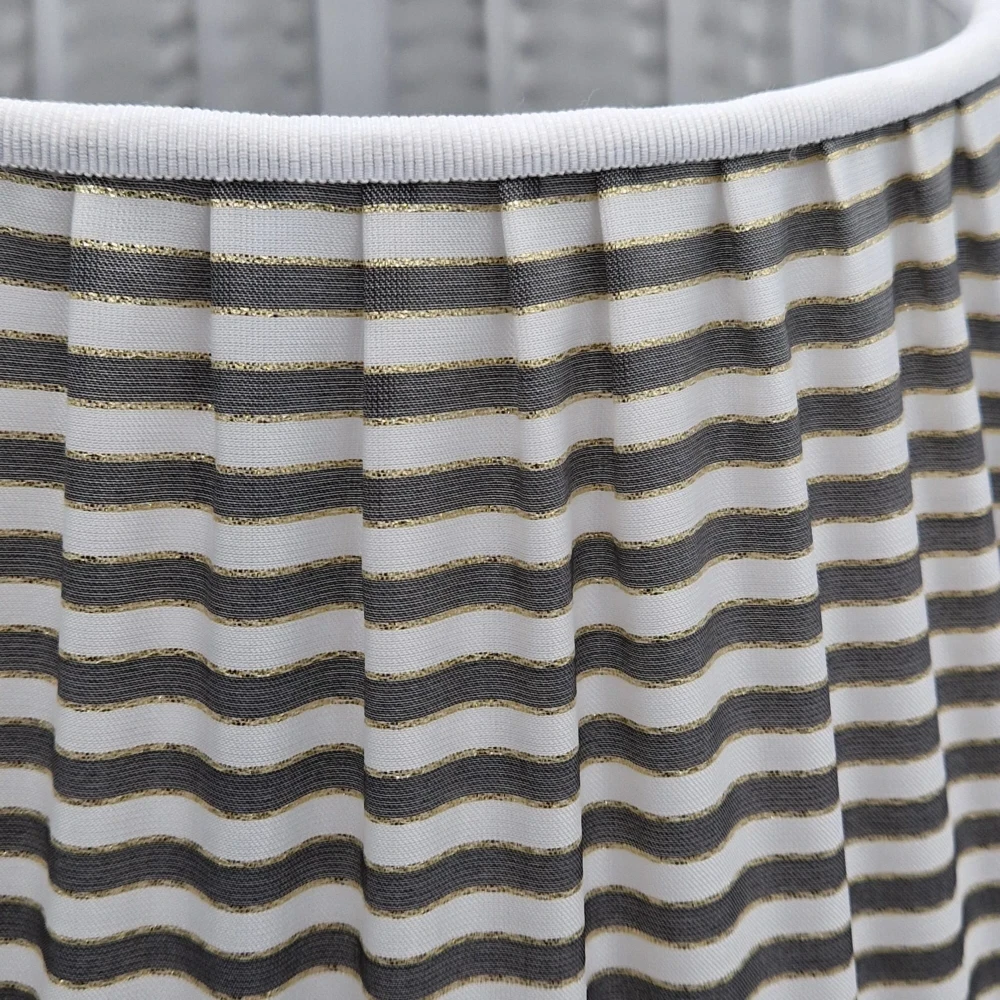Paralume plissettato a righe bianche e grigie con dettagli dorati. Particolare della passamaneria e lavorazione