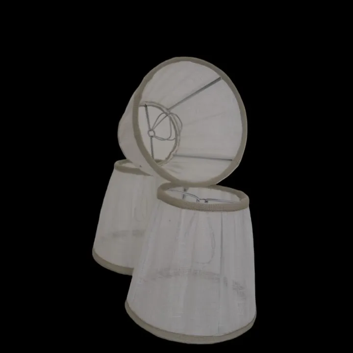 Paralumi per lampadari con attacco a molla Paralumi per lampadari con attacco a molla. Realizzati in lino bianco e rifiniti con passamaneria color sabbia