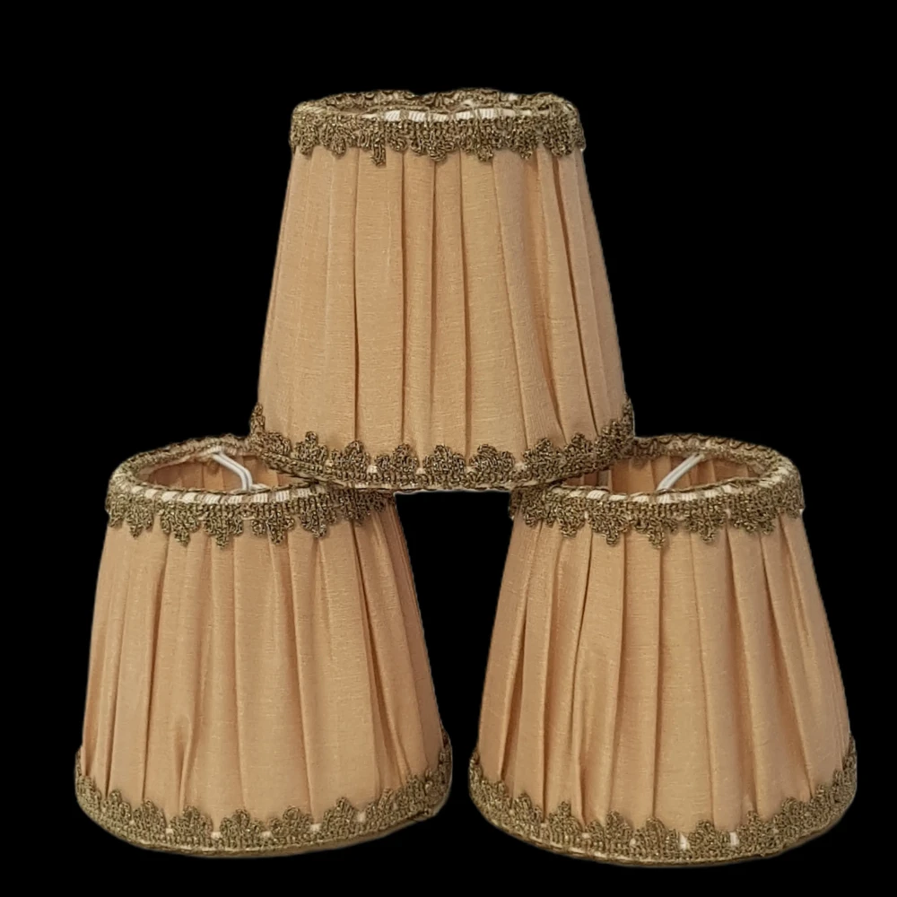 Paralumi per lampadari colore giallo oro e passamaneria dorata Paralumi a forma di tronco di cono in stoffa giallo oro con bordo dorato.