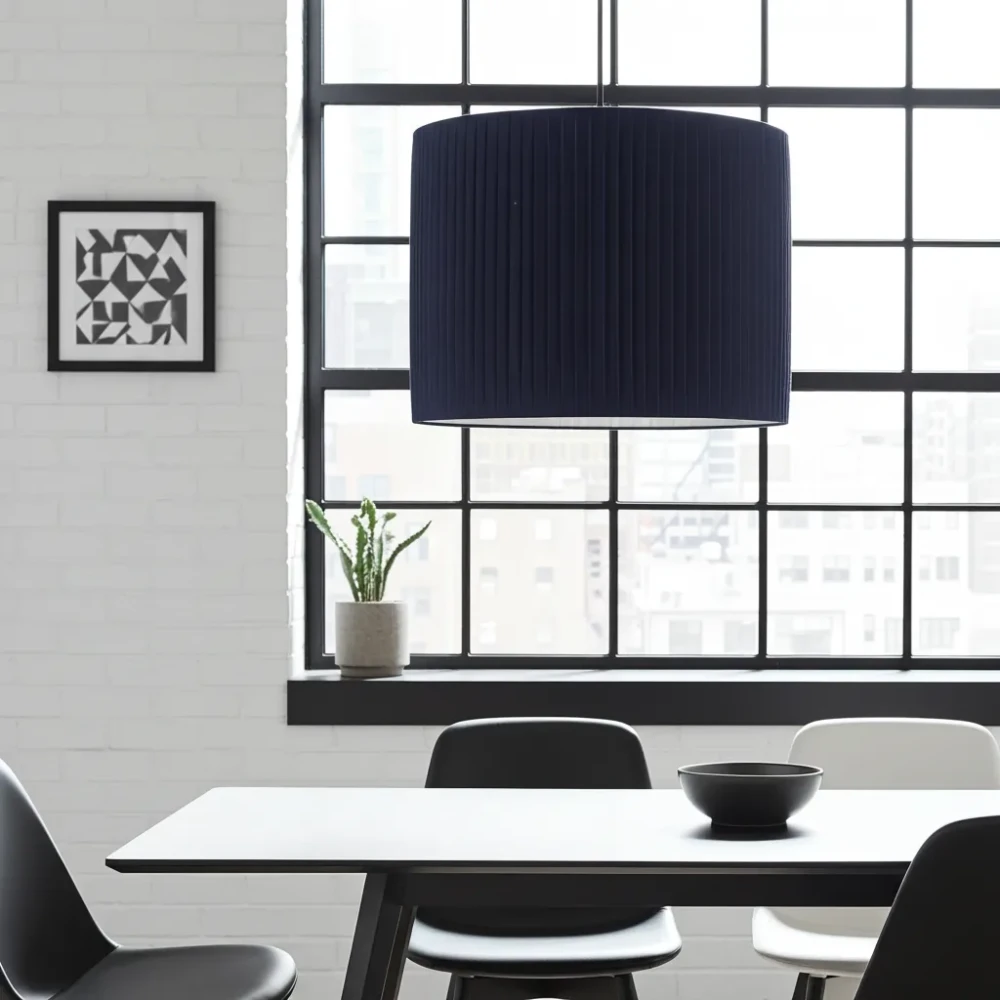 Paralume Cilindrico in Tessuto a Pieghe Colore Nero Paralume da soffitto di forma cilindrica, di colore nero, in tessuto con lavorazione a pieghe regolari, in un loft moderno.