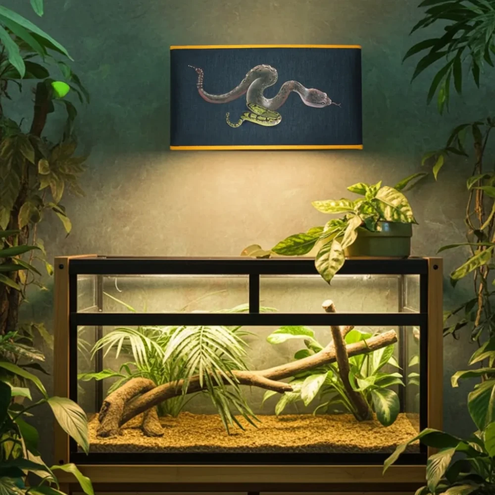 Paralume a Ventola da Muro Stampa Serpente – Ideale per Illuminare Teca Rettili Paralume rettangolare a ventola montato a parete con stampa di un grande serpente attorcigliato, che illumina una teca per rettili piena di piante e rami, in un ambiente che simula una giungla.