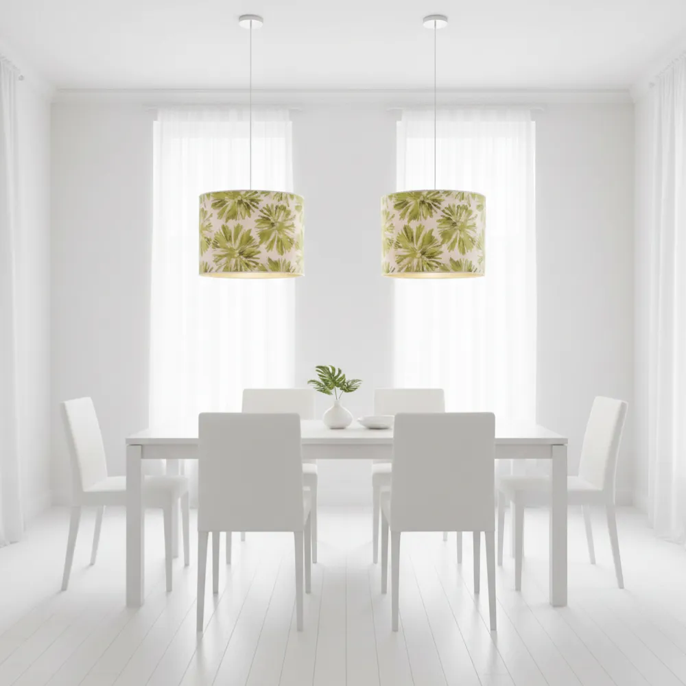 Coppia di paralumi cilindrici artigianali con fiori verdi utilizzati come lampadari a sospensione sopra un tavolo da pranzo bianco.Esempio di ambientazione