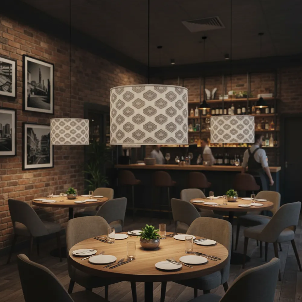 Allestimento di un ristorante moderno con paralumi a sospensione artigianali a rombi dorati sopra i tavoli.