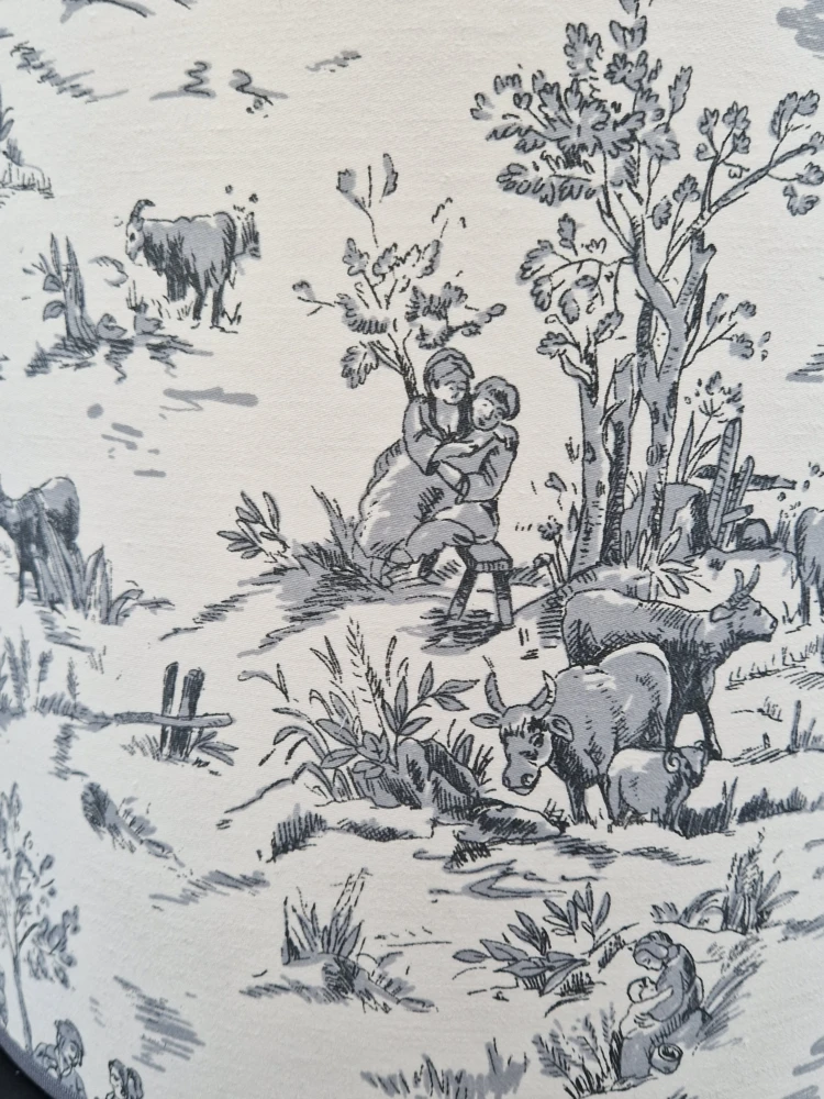 Particolare del tessuto Toile de Jouy grigio con scene bucoliche per paralumi fatti a mano a Prato.