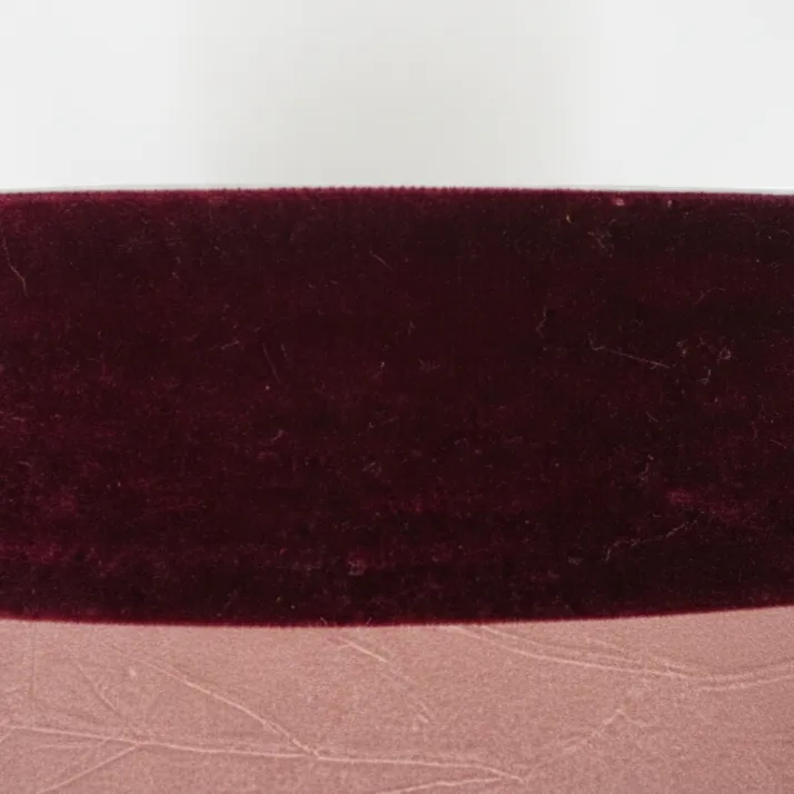 Dettaglio passamaneria in velluto bordeaux su paralume rosa stropicciato.