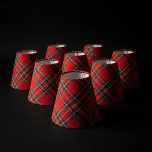 Set di piccoli paralumi artigianali (imperini) per lampadario in tessuto scozzese rosso, isolati su sfondo nero per risaltare la trama.