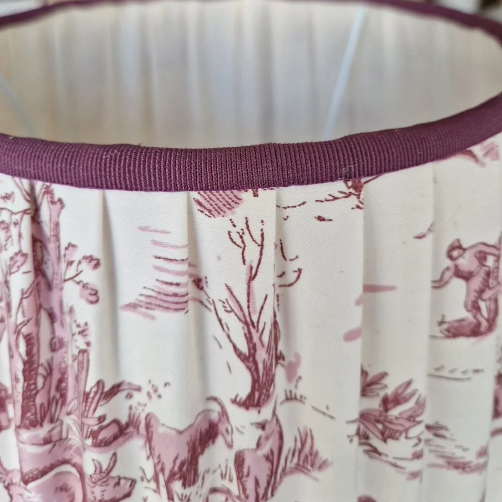 Dettaglio della passamaneria in grosgrain bordeaux su paralume a tronco di cono in stoffa Toile de Jouy arricciata